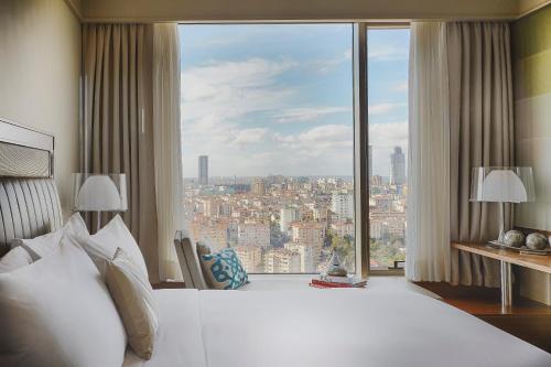 Habitación de hotel con cama grande y ventana grande. en Renaissance Istanbul Polat Bosphorus Hotel, en Estambul