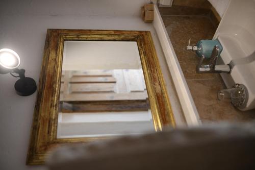 a mirror in a bathroom with a bed in the reflection at Nisanyan Hotel in Selcuk