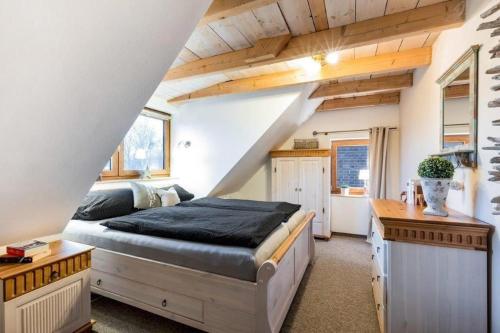 um quarto com uma cama grande num sótão em Kamin-Haus-Nr-2-mit-Sauna-in-Burg em Fehmarn