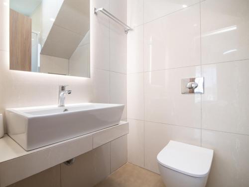 ein weißes Bad mit einem Waschbecken und einem WC in der Unterkunft Claudio Stone House in Vasilikos