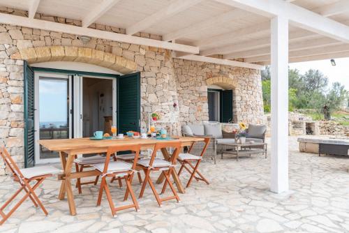 a wooden table and chairs on a patio at VILLA Alessandra in Marina di Pescoluse