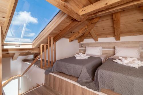 2 Betten im Dachgeschoss eines winzigen Hauses in der Unterkunft Claudio Stone House in Vasilikos