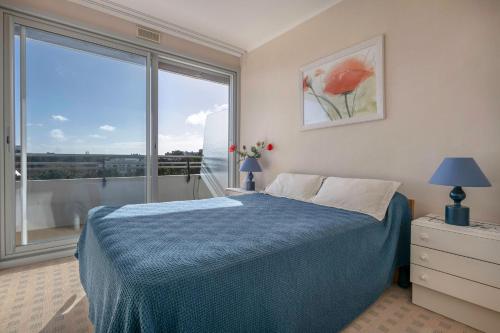 une chambre avec un lit et une grande fenêtre dans l'établissement Appartement à 150m de la plage, à La Baule