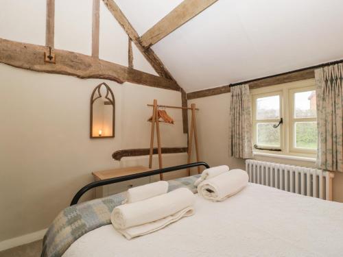 Schlafzimmer mit einem Bett und einem Fenster in der Unterkunft Pool Cottage in Hereford