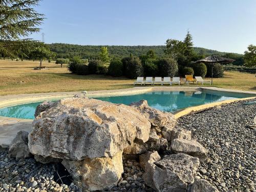 - une piscine avec un grand rocher dans la cour dans l'établissement Villa de charme à Saint-Maime avec piscine privée, à Saint-Maime