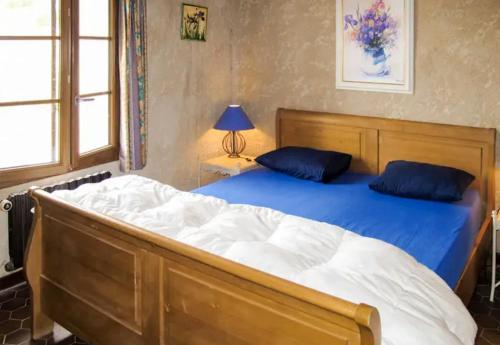 een slaapkamer met een groot houten bed met blauwe kussens bij Villa de 5 chambres avec piscine privee jardin amenage et wifi a Saint Maime in Saint-Maime