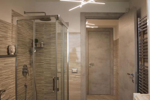 La salle de bains est pourvue d'une douche avec une porte en verre. dans l'établissement Villa Adriana B&B, à Misterbianco