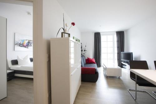 uma sala de estar branca com um sofá e uma mesa em Residenz am Balmer See - BS 09 mit Wellnessbereich em Balm
