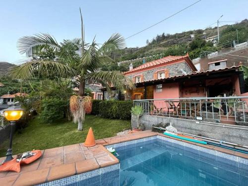 uma piscina em frente a uma casa em Secluded cottage w pool, oceanside view, 3BR, 3BA em Ponta do Sol