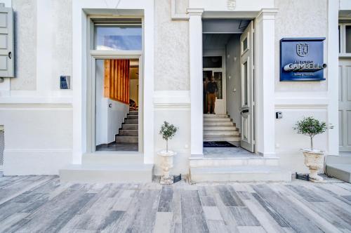 a white building with two plants in front of it at Gambello Luxury Rooms in Nafplio