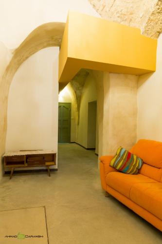 a living room with an orange couch in a building at Al-Hakim Boutique Hotel Old Town Nazareth in Nazareth
