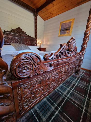 a large wooden bed with a wooden frame in a bedroom at Magpie 2 Hot Tub HuntersMoon-Warminster-Longleat-Wiltshire in Warminster