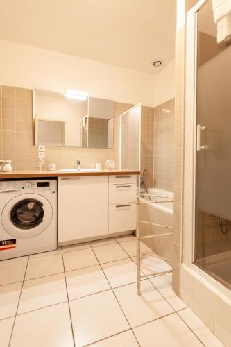 La salle de bains est pourvue d'un lave-linge et d'une douche. dans l'établissement Le Patio - Hypercentre - cour au calme - wifi, à Vannes