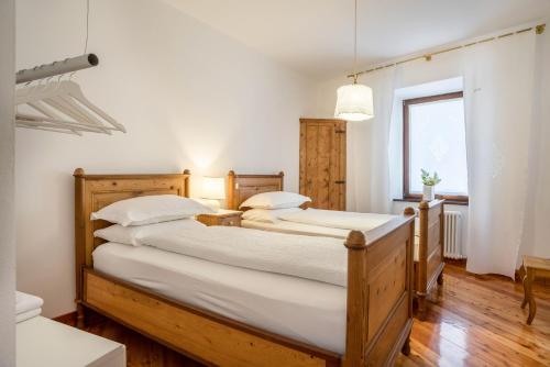 2 camas individuales en un dormitorio con paredes blancas en Wunderhorn, en Civezzano