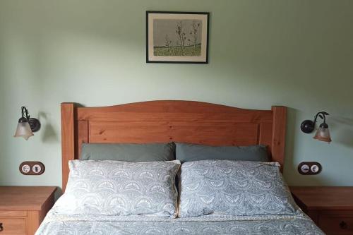 a bedroom with a bed with a wooden headboard and lights at Apartment in country house with views and pool in Vespellá