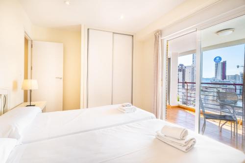 a bedroom with two beds and a large window at Coblanca 3-105 in Benidorm