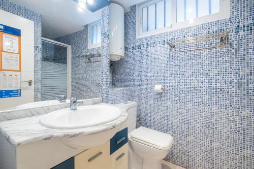 a blue tiled bathroom with a sink and a toilet at Coblanca 3-105 in Benidorm