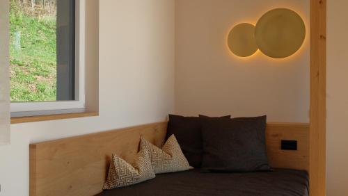 a bedroom with a bed with pillows and a window at Runk Apartments in Siusi