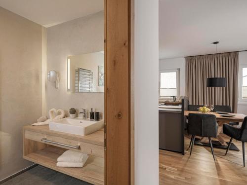 een badkamer met een wastafel en een bureau bij monas home mayrhofen in Mayrhofen