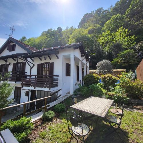a house with a table and chairs in the yard at Casa delle azalee in Gravellona Toce