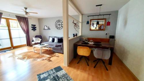 una sala de estar con escritorio y una habitación con sofá en Bergliebe, en Germaringen