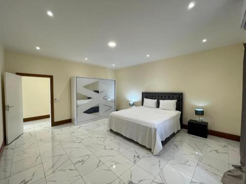 ein Schlafzimmer mit einem Bett und einem großen Marmorboden in der Unterkunft Holiday Home in São Tomé in São Tomé
