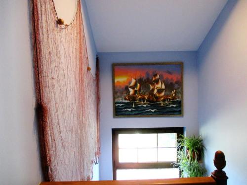 a room with a painting on the wall and a window at Apartamentos rurales la Aguilera in Oviñana