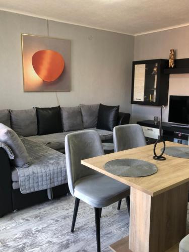 a living room with a couch and a table and chairs at Centre apartment in Prilep