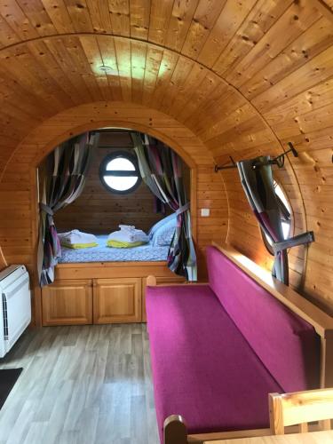 a small bedroom with a purple couch in a wooden room at EI Domaine du Bouygues chambres d'hôtes in Le Juge
