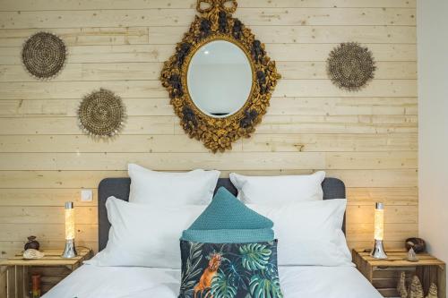 sypialnia z łóżkiem z białymi poduszkami i lustrem w obiekcie Le Joyau ! Brillant & Chic - Park. Privé - Premium w Troyes