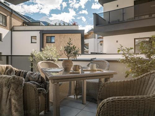a patio with a table and chairs on a balcony at monas home mayrhofen in Mayrhofen