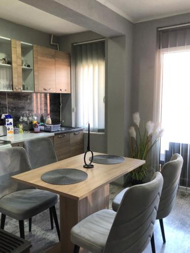 a kitchen with a wooden table and chairs at Centre apartment in Prilep