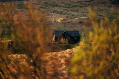 a house in the middle of a field at Hvammsvík Nature Resort in Kjósahreppur