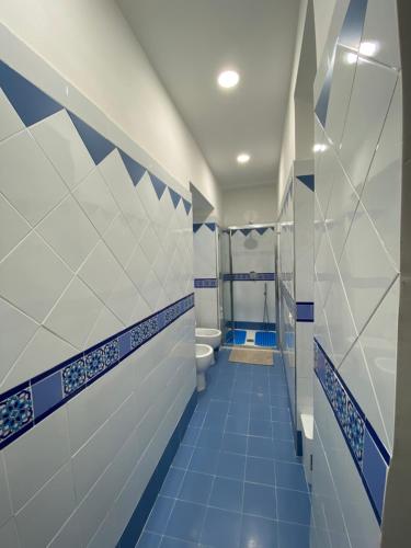 een badkamer met blauwe en witte tegels en een toilet bij Dar Zohra in Pozzuoli