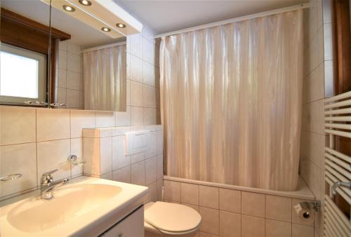 ein Bad mit einem Waschbecken, einem WC und einer Dusche in der Unterkunft Haus Viols 46 in Savognin