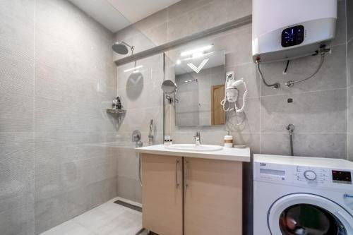a bathroom with a washing machine and a sink at City Apartments 2 in Budva