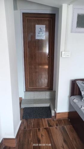 a wooden door in a room with a wooden floor at Darjeeling Homestay Nyano Ghar in Darjeeling