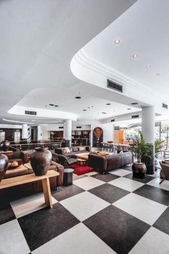 a lobby with couches and a checkered floor at Jacob Eilat in Eilat