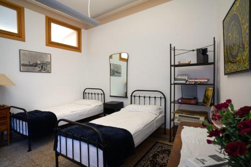 2 Betten in einem Zimmer mit weißen Wänden und einem Tisch in der Unterkunft Casa dell'Architetto MyTravelChioggia in Chioggia
