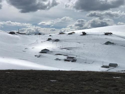 uma colina coberta de neve com casas em cima dela em KULAT DAĞ EVİ em Gumushane