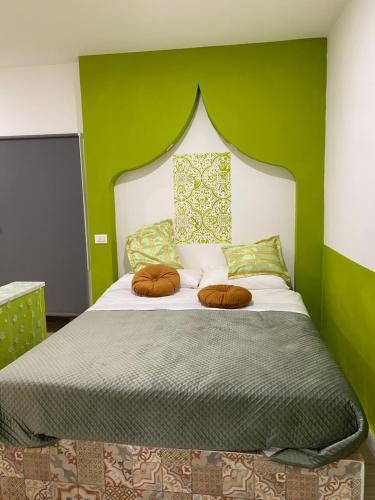 een slaapkamer met een bed met een groene muur bij Dar Zohra in Pozzuoli