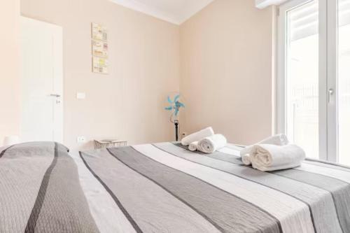 a white bedroom with a large bed with towels on it at Poste Rooms 28 in Sava