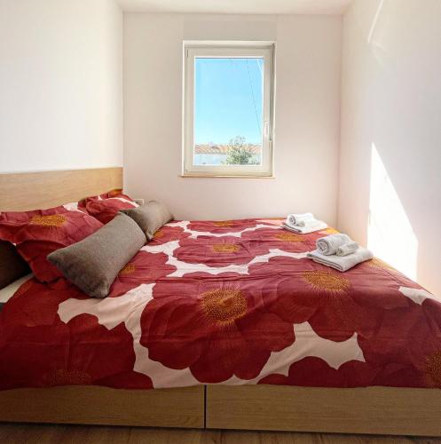 a bedroom with a red and white bed with a window at Sara&Sera in Umag