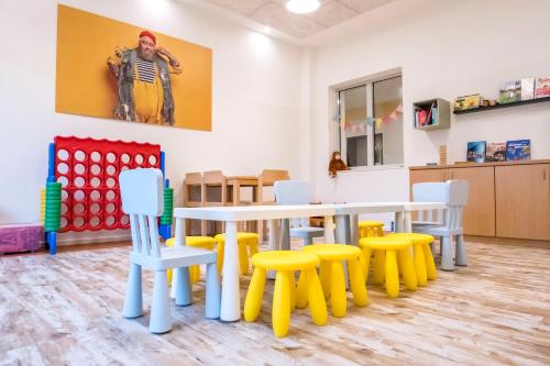 a room with a table and some yellow and white chairs at Jugendherberge Büsum in Büsum