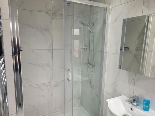 a white bathroom with a shower and a sink at Newly Built Studio Flat Sleeps 2 in Kent