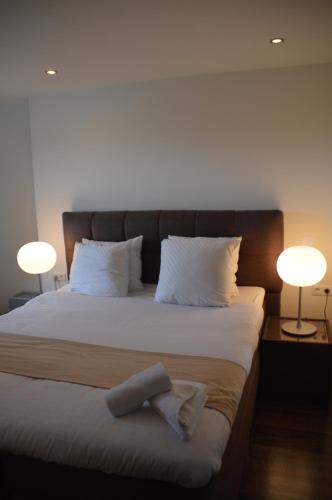 a bedroom with a large bed with two lamps at Hotel La Belle Vue in Amsterdam