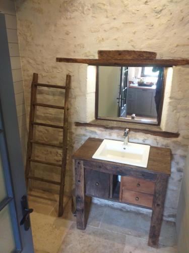 une salle de bain avec un lavabo et un miroir dans l'établissement Gite du moulin, à La Mothe-Saint-Héray