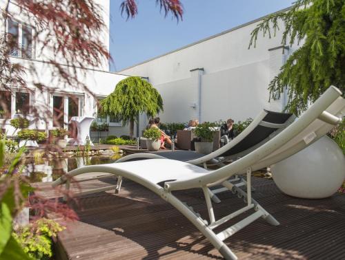 a white lounge chair sitting on a patio at Hotel Residenz in Bocholt