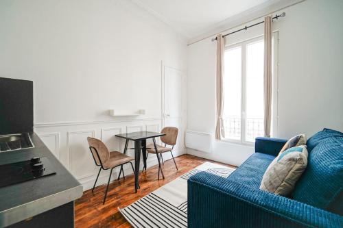 un salon avec un canapé bleu et une table dans l'établissement Niepce - Blue flat next to Avenue du Maine, à Paris