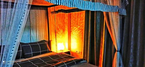 a bedroom with a bed with curtains and a lamp at Mount Elegance in Nuwara Eliya